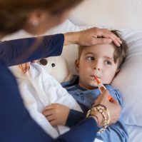 Sick boy getting temperature checked